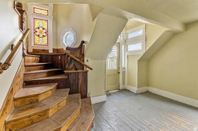 Original curved wood staircase and stained glass window